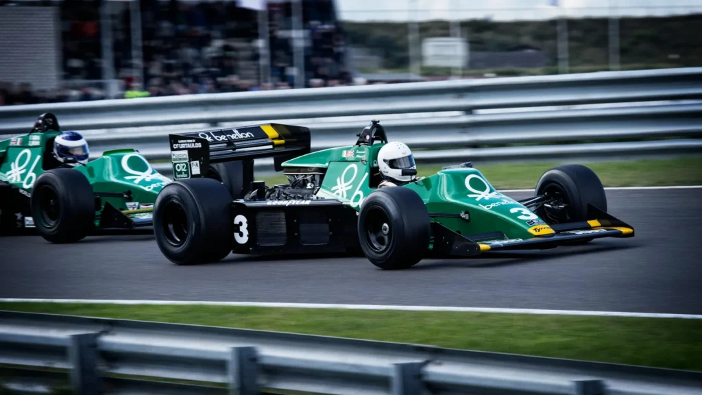 Action-packed shot of classic Formula 1 cars racing on a speedway, showcasing speed and competition.
