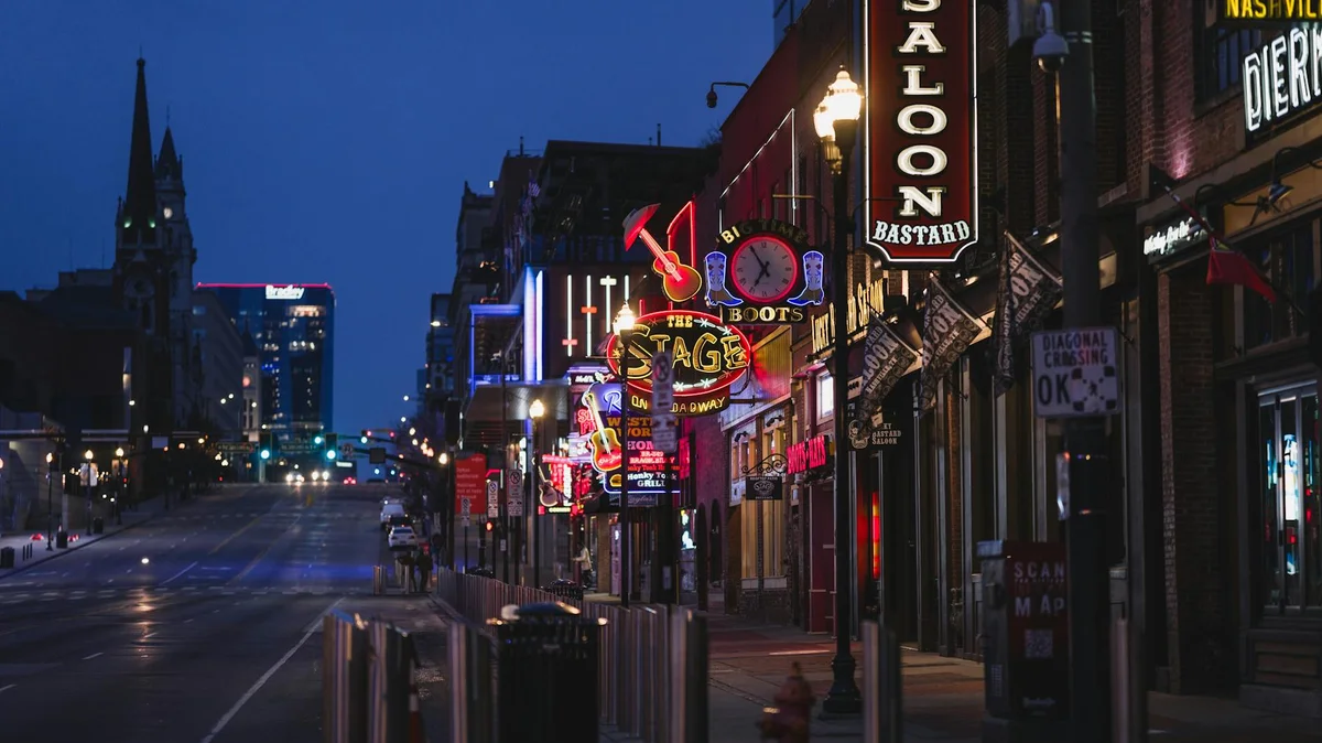 Nashville Broadway street with neon honky-tonk signs and bustling nightlife during CMA Fest week