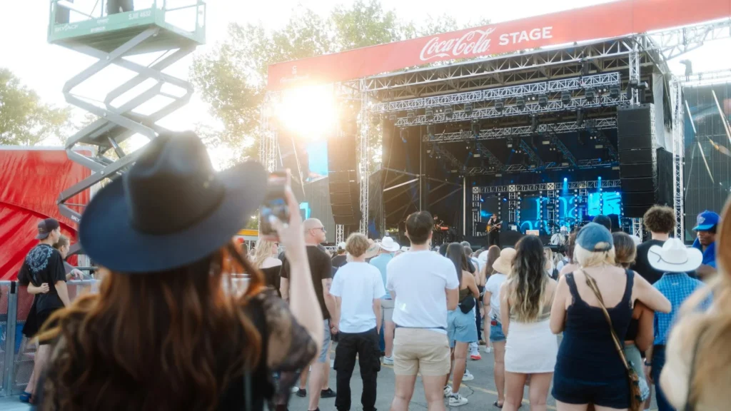 Country music festival crowd watching outdoor concert at sunset with cowboy hats at Stagecoach Festival 2026