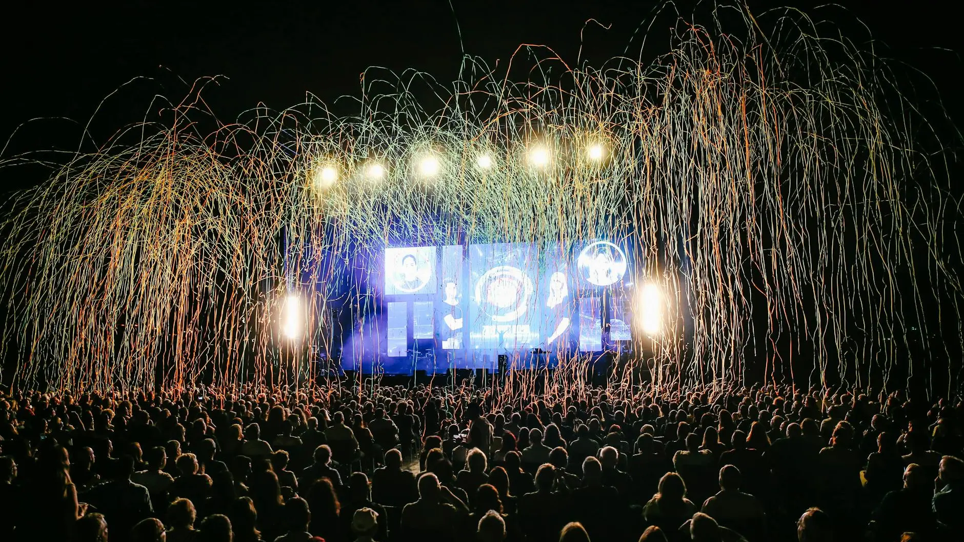 Outdoor concert venue with massive crowd and confetti at a country music festival