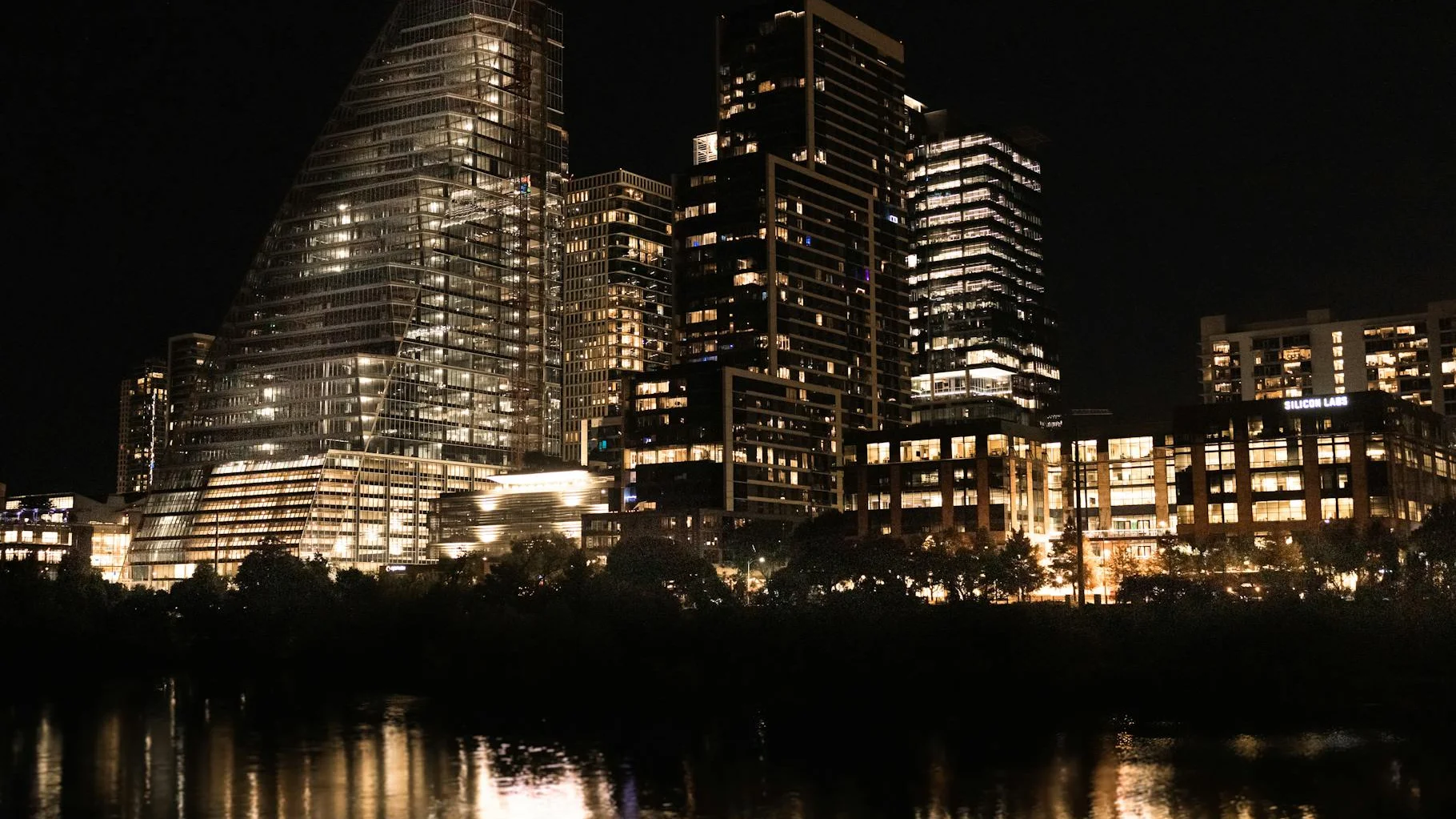 Austin Texas skyline illuminated at night over Lady Bird Lake