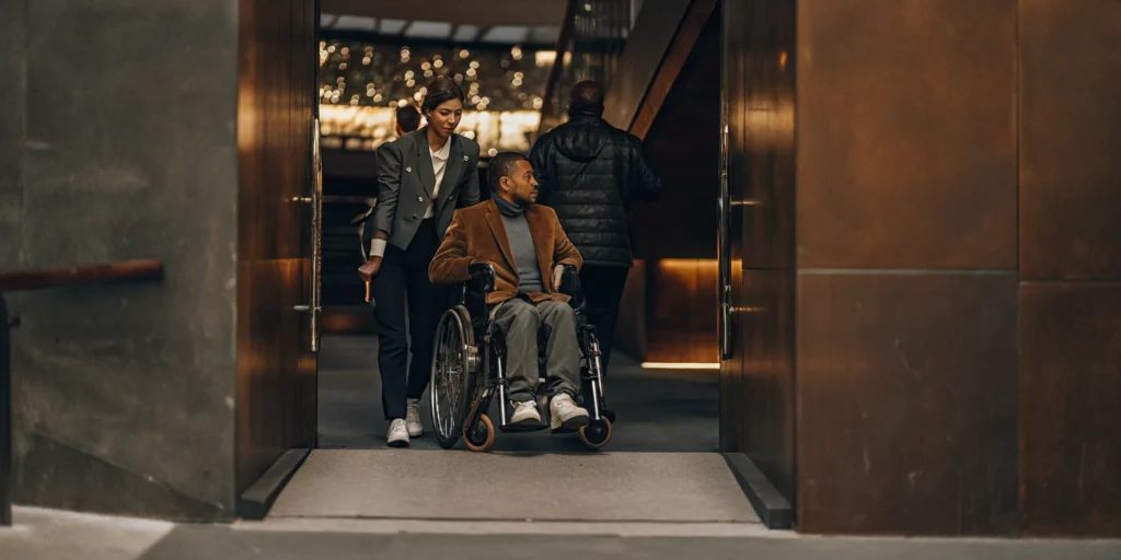 Guest using a wheelchair arriving for accessible VIP sports travel at a stadium
